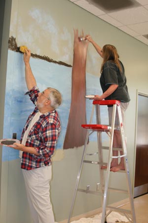 image of two seniors painting a wall mural